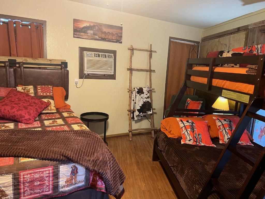 a bedroom with two bunk beds and a ladder at Acorn Hideaways Canton Old Western Ranch Hands' Suite in Canton
