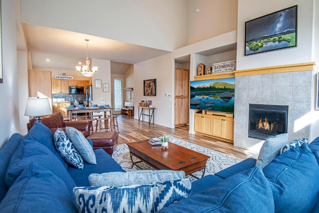 雷德蒙德Whispering Creek - Meredith Lodging的带蓝色沙发和壁炉的客厅