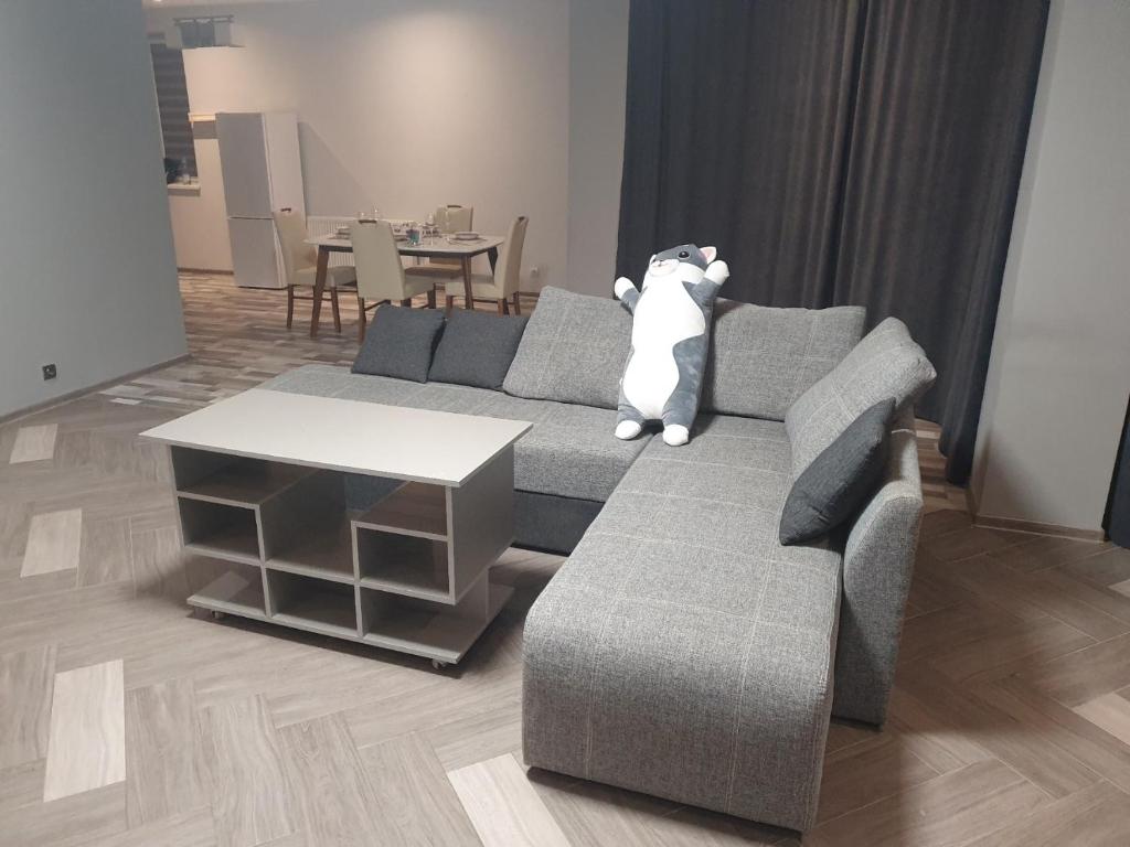 a teddy bear sitting on a couch in a living room at NEW апартаменты на Гвардейской in Uzhhorod