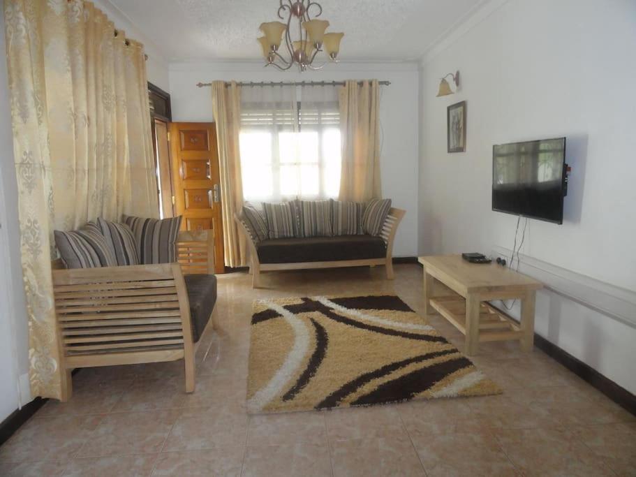 salon z kanapą i telewizorem w obiekcie Larry's Place w mieście Kampala