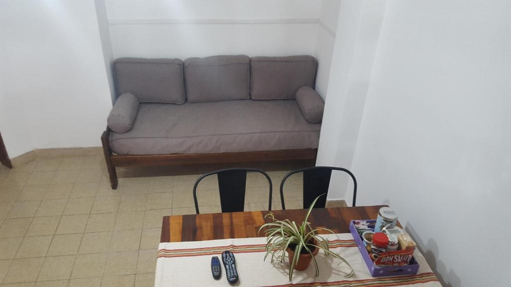 sala de estar con sofá, mesa y sillas en CONFORTABLE DEPARTAMENTO CÉNTRICO en Salta