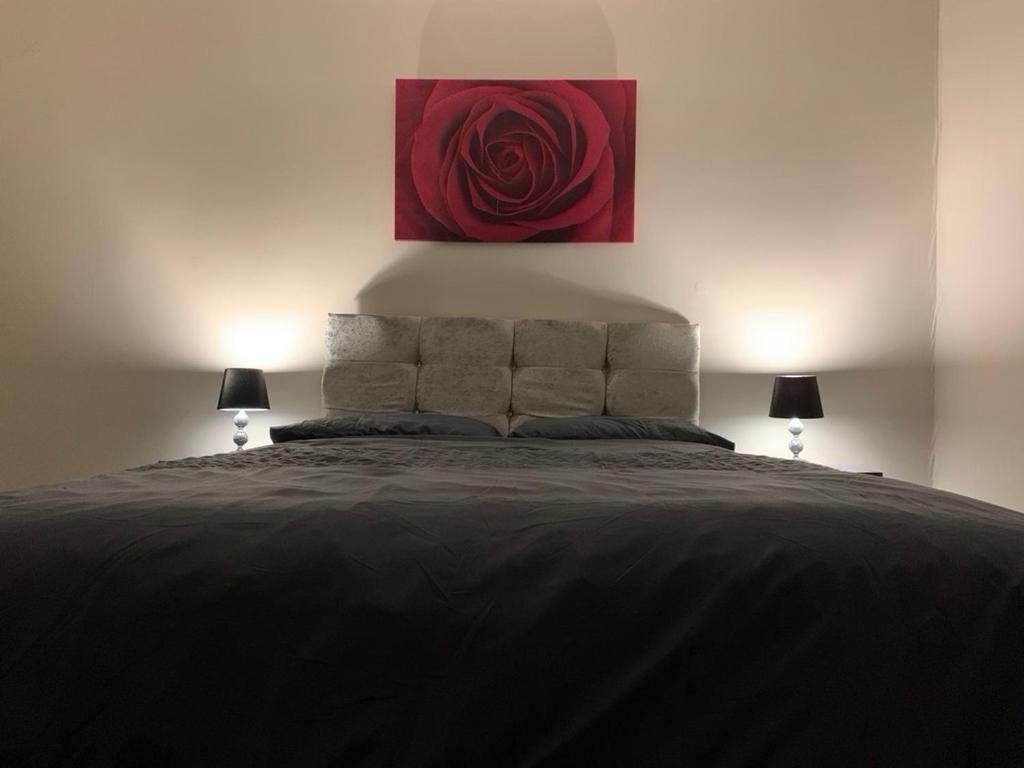 a bedroom with a large bed with a red painting on the wall at One Bedroom Apartment Near QMC & University of Nottingham in Nottingham