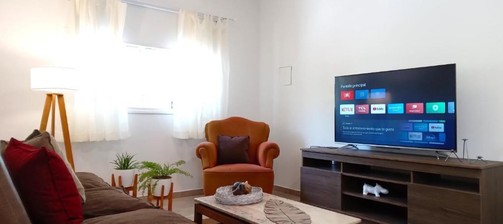 sala de estar con sofá y TV de pantalla plana en Encantador departamento a estrenar en Mendoza