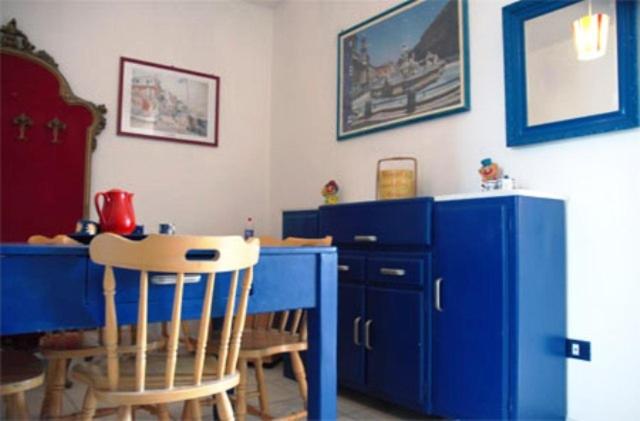 cocina con armarios azules, mesa y sillas en Casa Carolina, en Agropoli