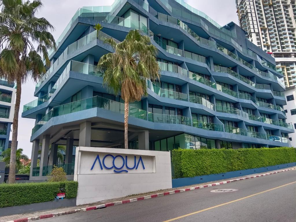 a building with a palm tree in front of it at Acqua Condominium Jomtien in Jomtien Beach