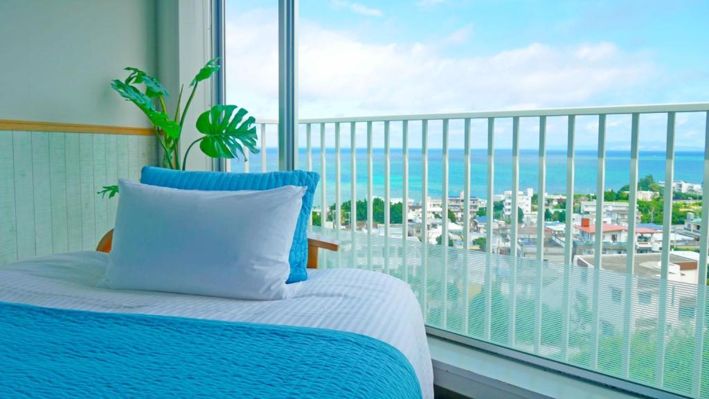 1 dormitorio con cama y vistas al océano en Coral Garden 7 Pools, en Yomitan