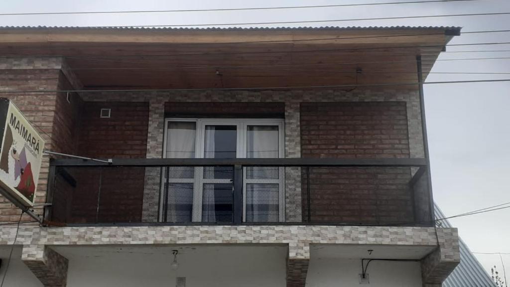 - Balcón en un edificio de ladrillo con ventana en El lucero en Los Antiguos