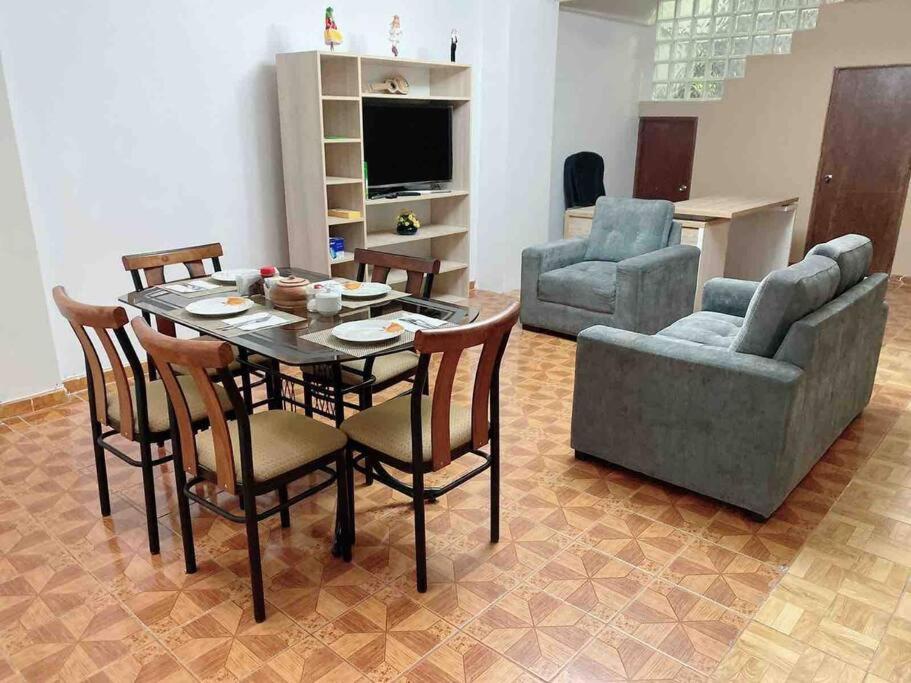 a living room with a table and chairs and a television at Apartamento a 10 min del centro de la ciudad in Huaraz