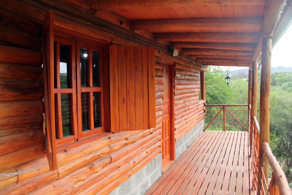 un porche de madera de una cabaña con ventanas en La Idalina en Córdoba