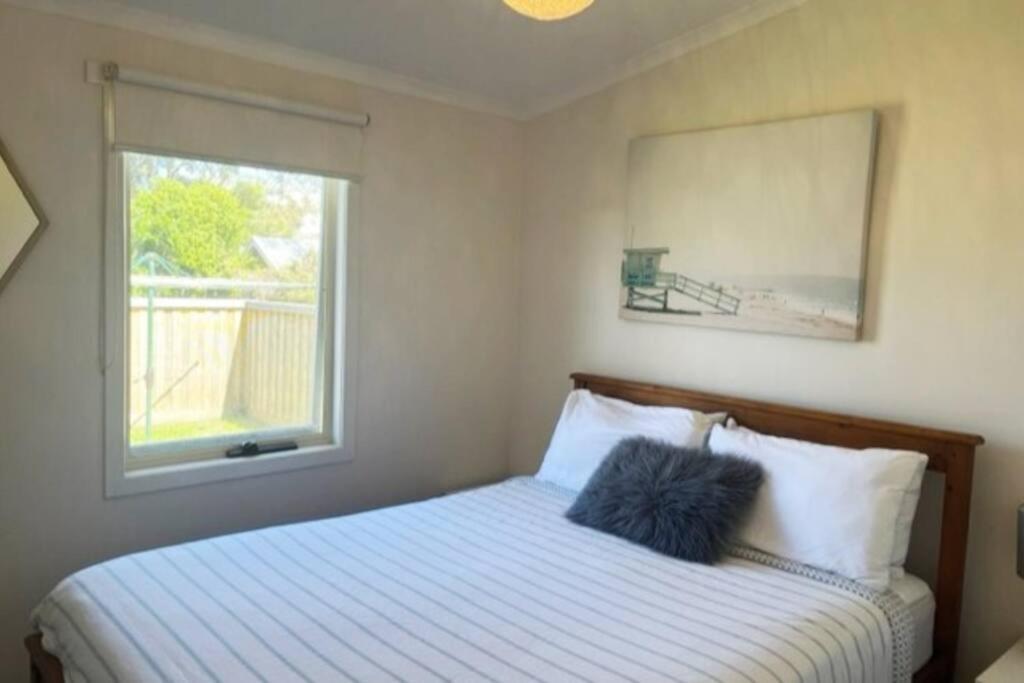 1 dormitorio con 1 cama y ventana en Apollo Bay Rocket House l Pet-Friendly Free Wi-Fi, en Apollo Bay