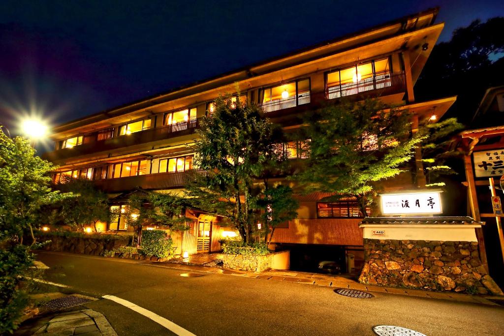 ein Gebäude mit einer Straße in der Nacht davor in der Unterkunft Kyoto Arashiyama Onsen Ryokan Togetsutei in Kyoto