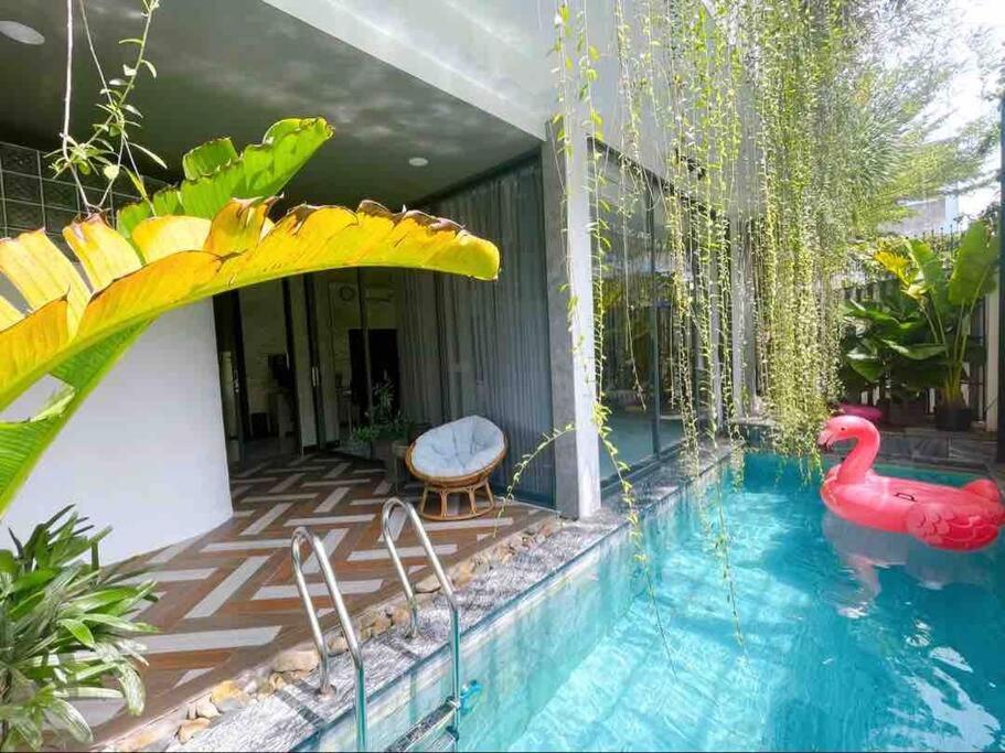 una piscina con cigno rosso nel mezzo di una casa di Holi Cheerful Pool Villa a Nha Trang