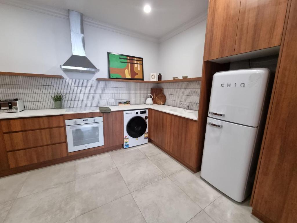 a kitchen with a white refrigerator and a dishwasher at The Sherwood Hotel in Lismore