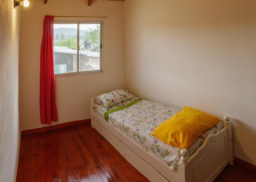 Habitación pequeña con cama y ventana en Temporario Patagonia en El Bolsón