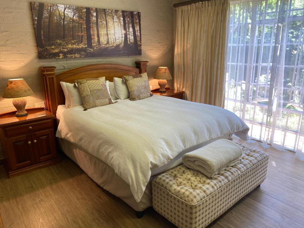 Un dormitorio con una cama grande y una ventana en Anne's Place, en Potchefstroom