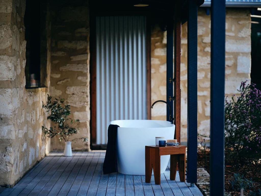 eine Badewanne auf einer Terrasse neben einem Tisch in der Unterkunft Burnside Organic Farm in Margaret River Town