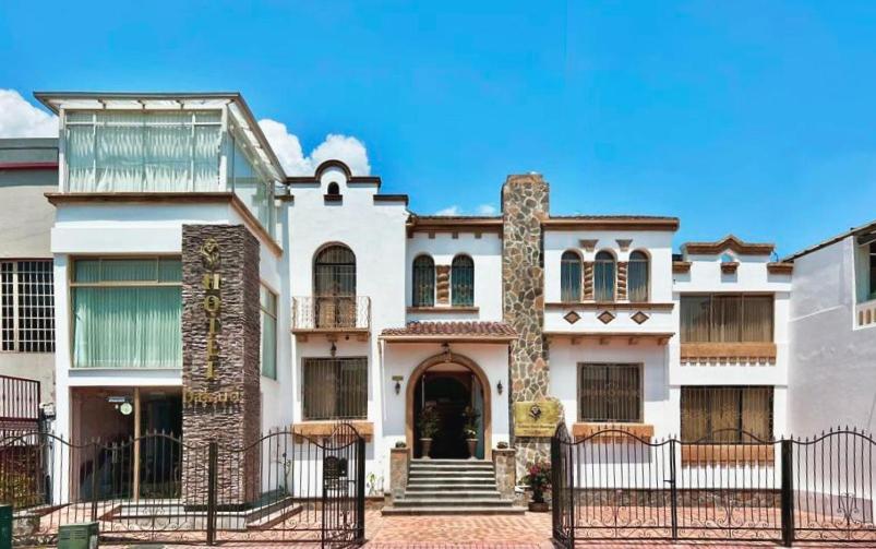 a large house with a gate in front of it at Dakani Hotel Boutique NEW in Quito