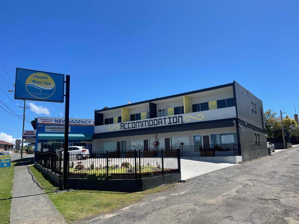 un bâtiment avec un panneau devant lui dans l'établissement Aquatic Motor Inn, à Taree