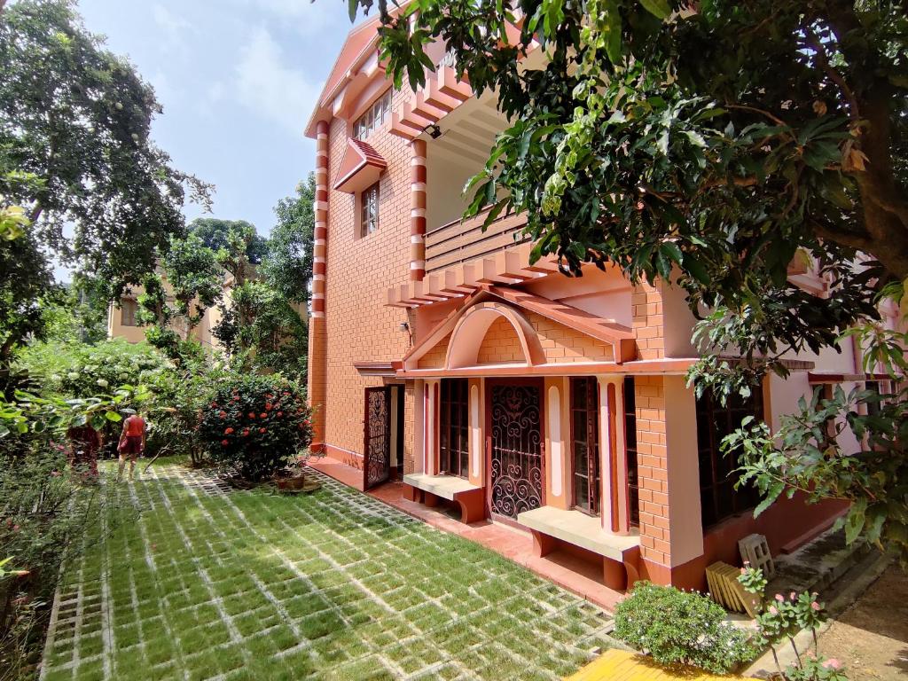 a house with a lawn in front of it at Abode of Peace in Bolpur