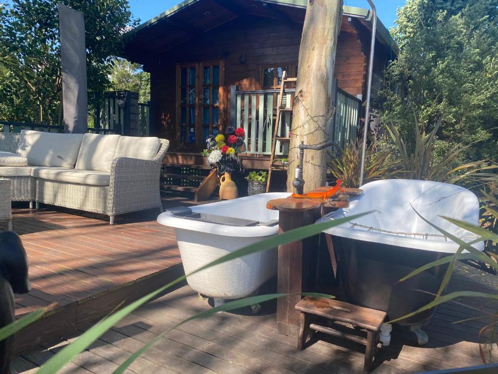 a bath tub sitting on a deck next to a house at A place to be in Kurmond