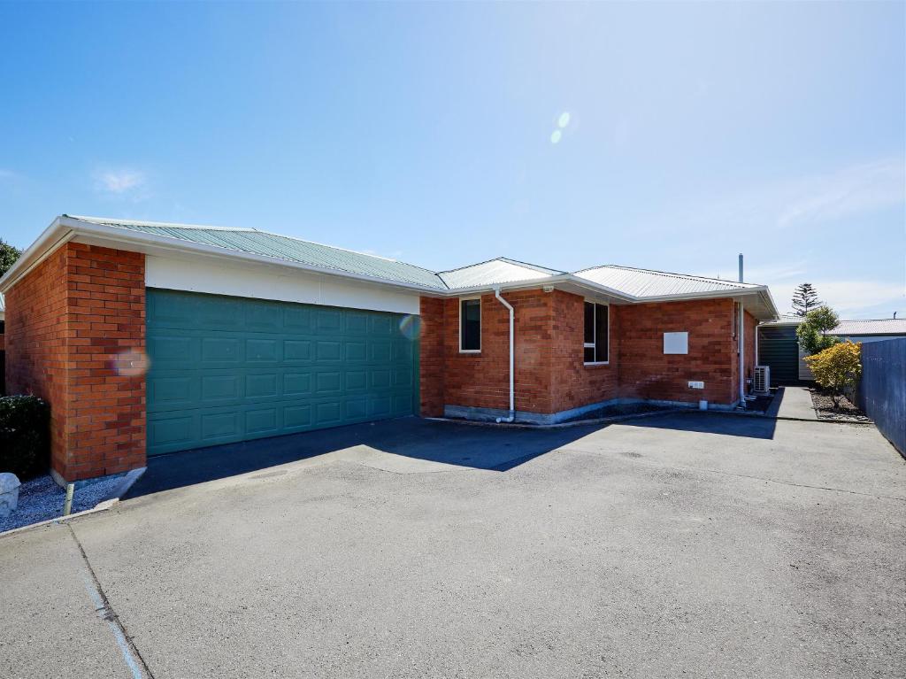a brick house with a garage and a driveway at Torquay Central - Kaikoura Holiday Home in Kaikoura