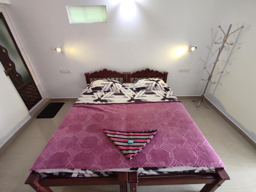 - un lit avec une couverture violette dans l'établissement Marari brezza homestay, à Alappuzha