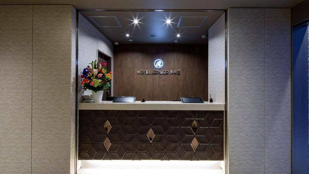 a lobby with a mirror and flowers on the wall at Hotel Reference Tenjin III in Fukuoka
