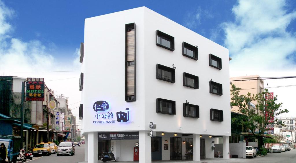 a white building with black windows on a street at 仁愛小公館-市區近東大門 in Hualien City