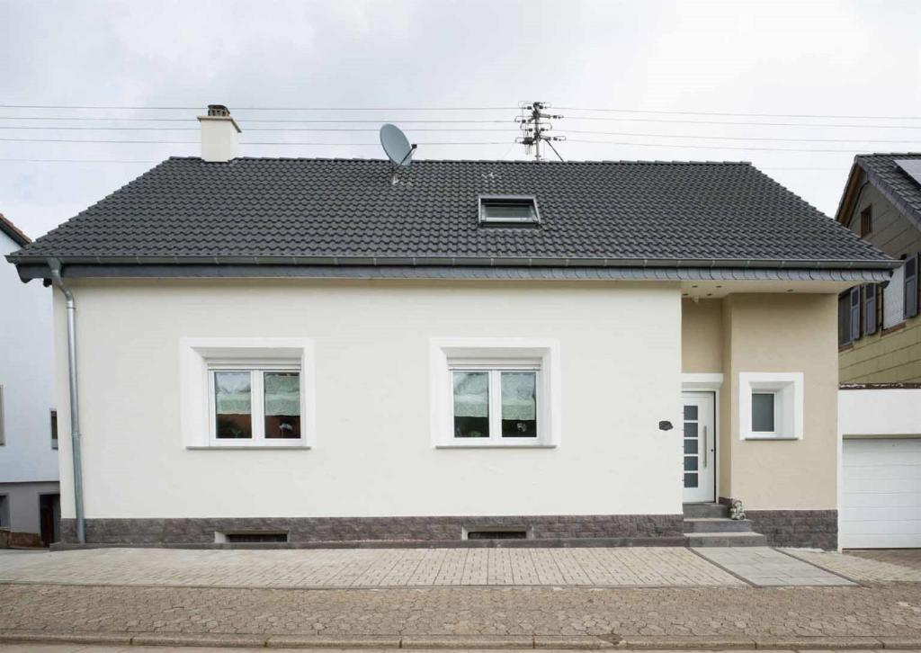 une maison blanche avec un toit noir dans l'établissement Ferienhaus Müller, à Merzig