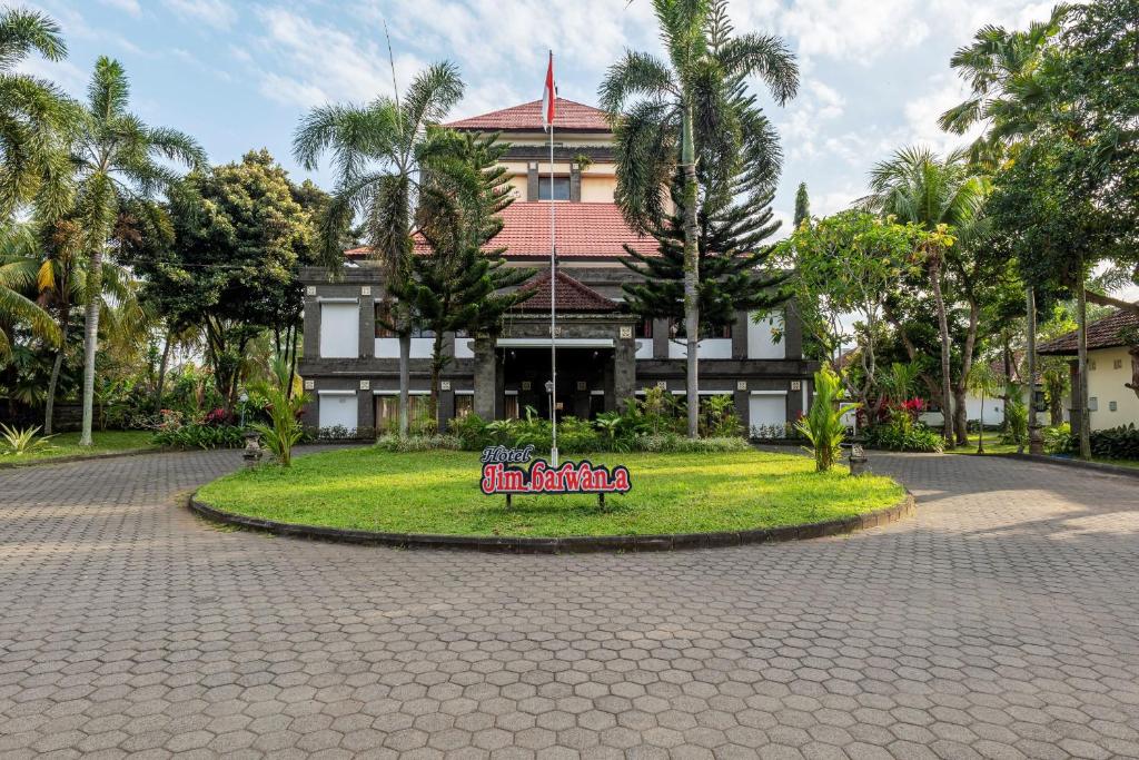 a building with a sign in the middle of a park at Jimbarwana Hotel in Negara