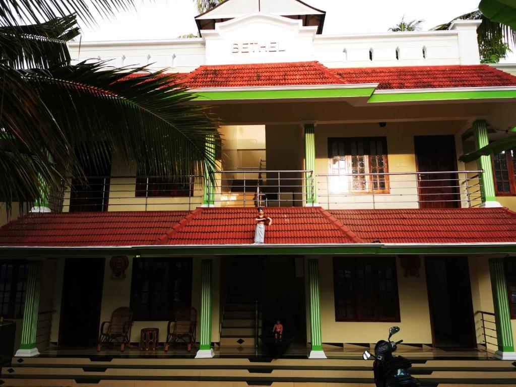 ein Motorrad, das vor einem Gebäude mit rotem Dach geparkt ist in der Unterkunft J2 Home Stay - Luxury Homes with Caravan Services in Thiruvananthapuram