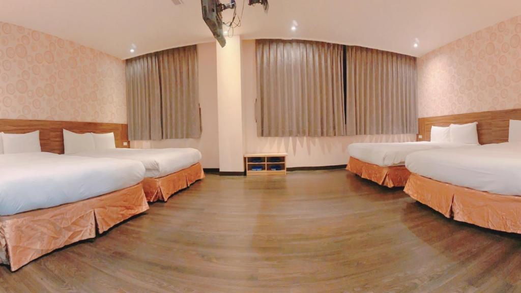 a hotel room with two beds and two windows at Centre Hotel in Kaohsiung
