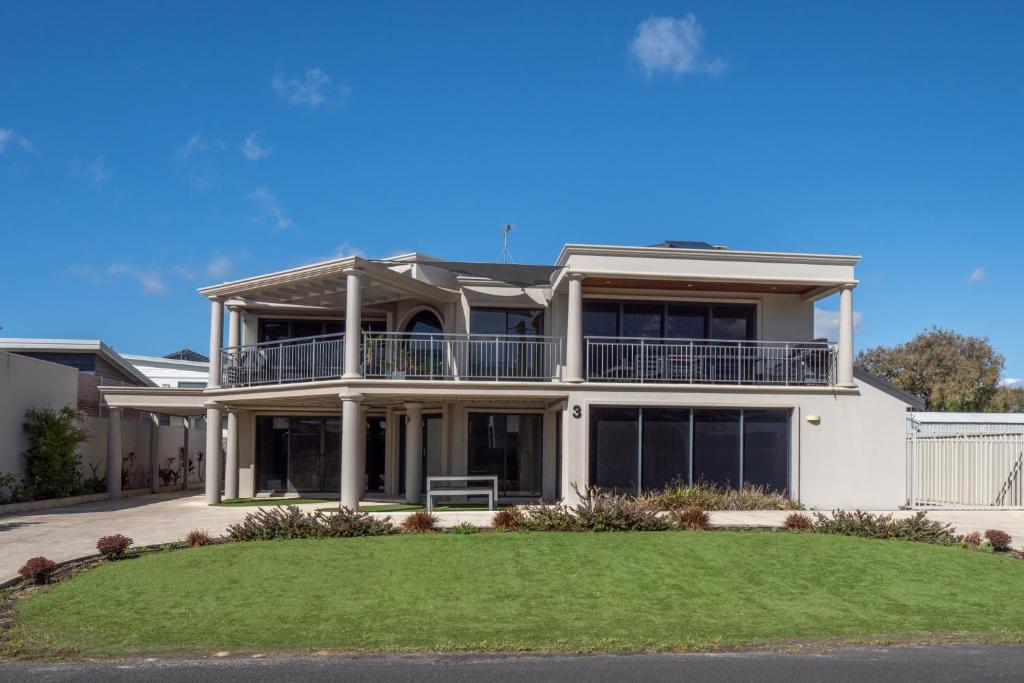 a large white house with a lawn in front of it at Ocean View Executive Apartment 2 in Busselton