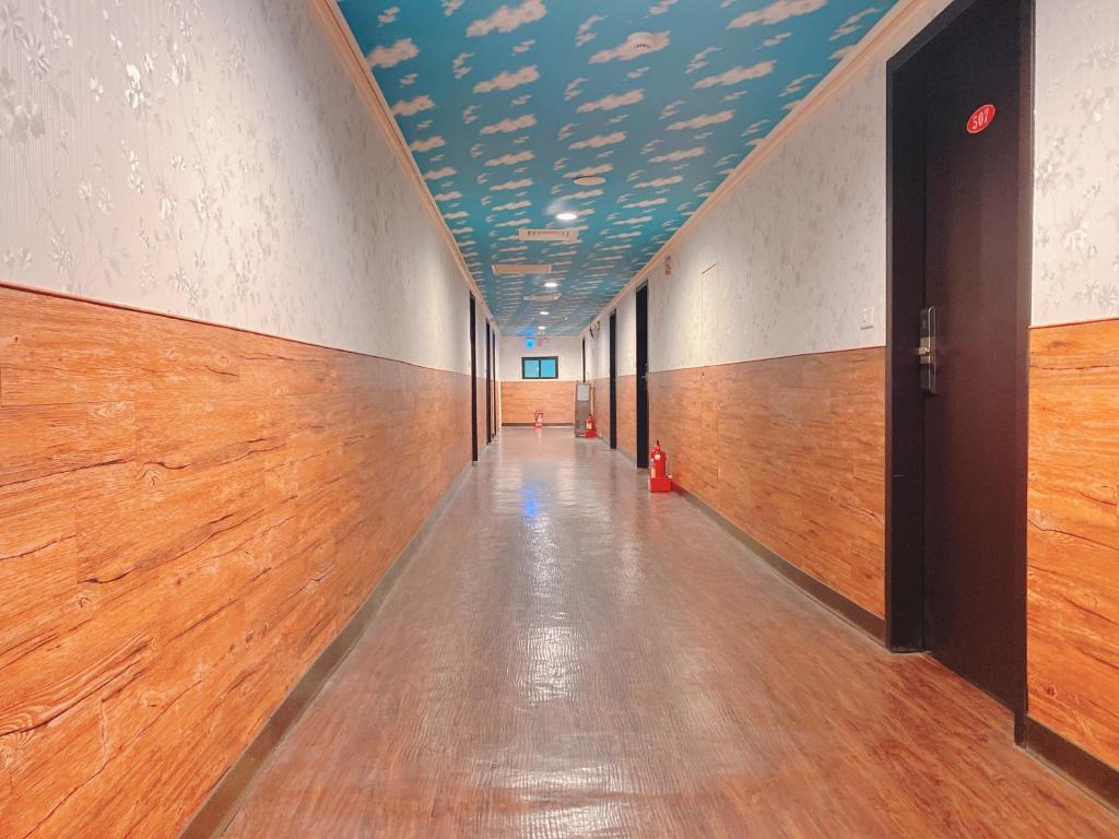 an empty hallway with a blue ceiling and wooden floors at Centre Hotel in Kaohsiung