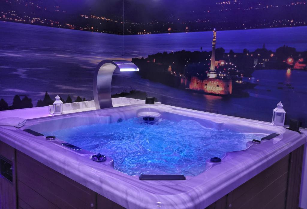 eine Whirlpool-Badewanne mit Blick auf die Stadt in der Nacht in der Unterkunft Messina41 Hotel in Messina