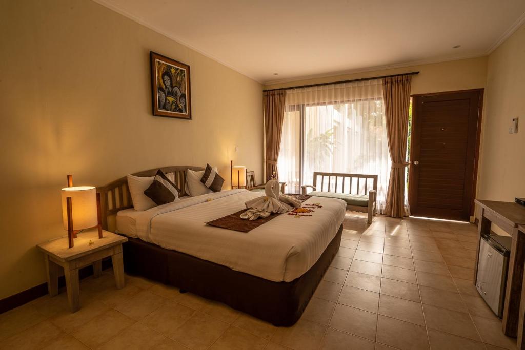 a bedroom with a large bed and a window at New Sunari Lovina Beach Resort in Lovina