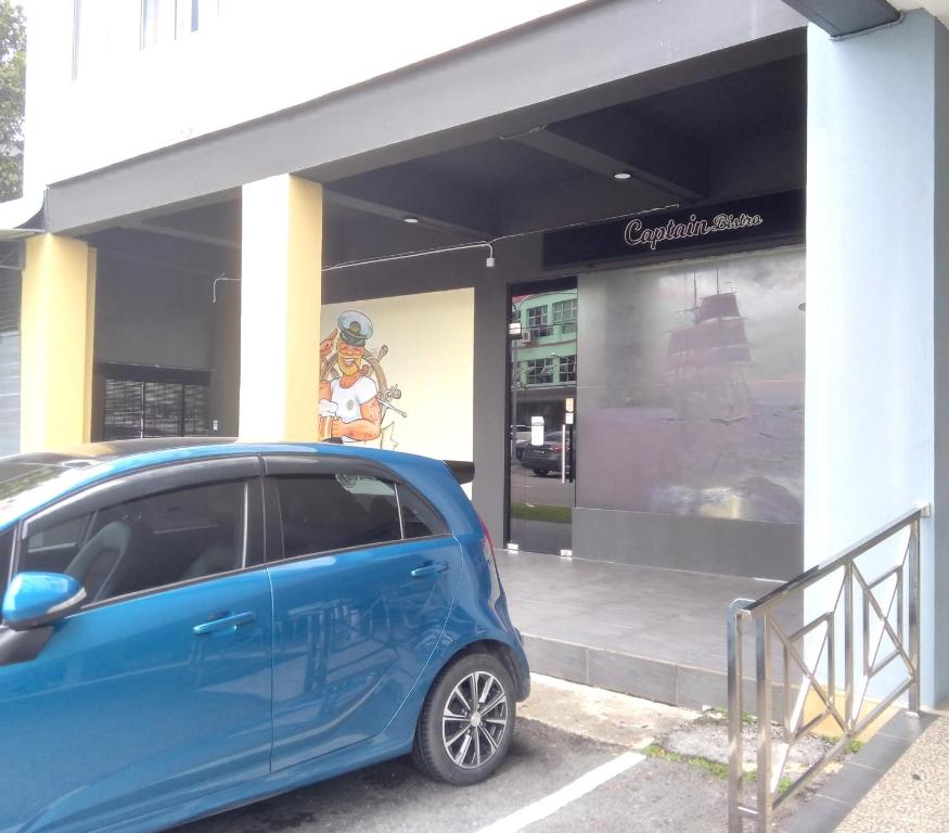 a small blue car parked in front of a store at 101 Hotel Bintulu in Bintulu