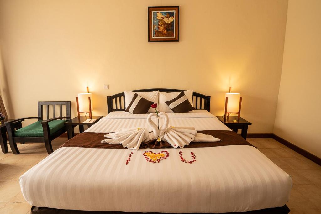 a bedroom with a large white bed with a bow on it at New Sunari Lovina Beach Resort in Lovina