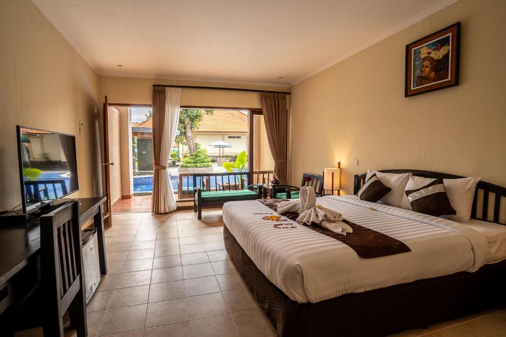 a bedroom with a large bed and a balcony at New Sunari Lovina Beach Resort in Lovina