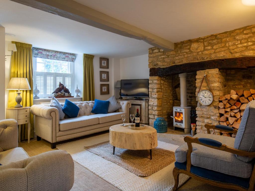a living room with a couch and a fireplace at Fairview Cottage in Moreton in Marsh
