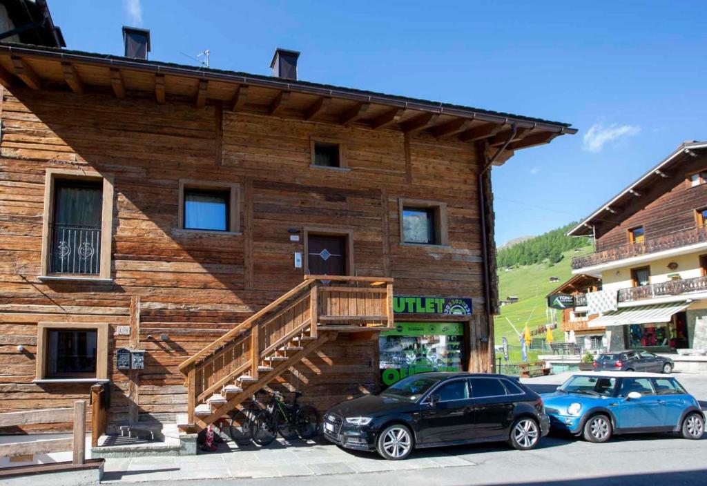 a wooden building with cars parked in front of it at Appartamento Dina in Livigno