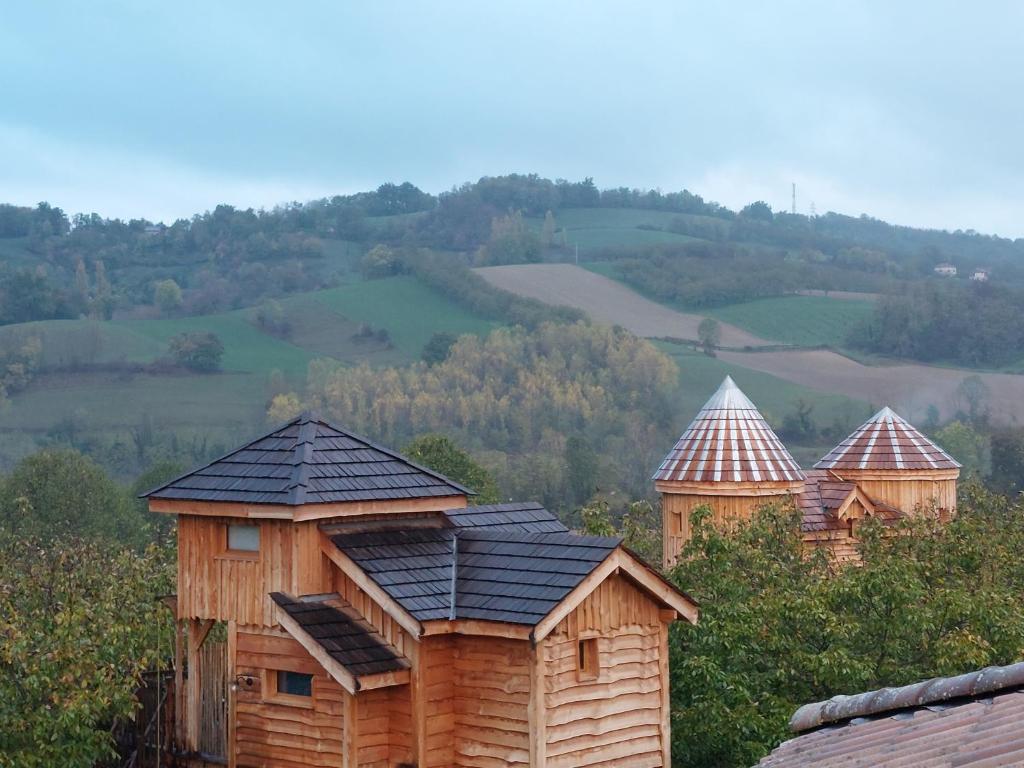 un grupo de casas de madera sentadas en la cima de una colina en Roulottes au pied du Vercors, en Saint-Jean-en-Royans