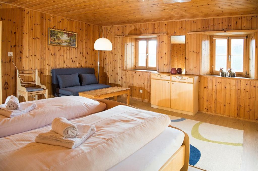 two beds in a room with a kitchen and a living room at Haus Schmitten - Davos in Schmitten