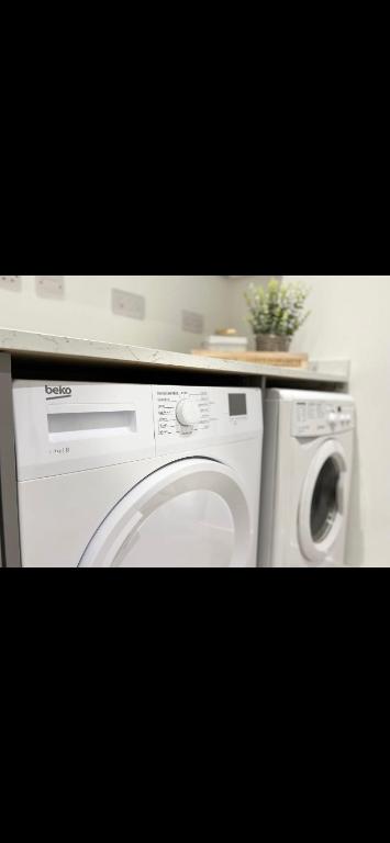 a washing machine and a washer in a kitchen at Homely and Deceptively large city house in Swansea