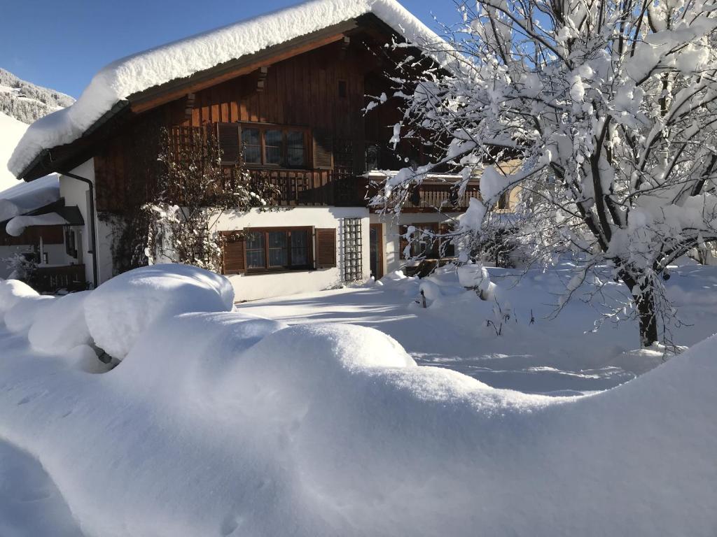 een huis bedekt met sneeuw met een berg sneeuw bij Apartment Ilishof in Schruns