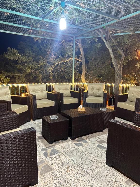 a patio with couches and tables and a tree at AlSalti Farm - مزرعة السلطي in Ajloun