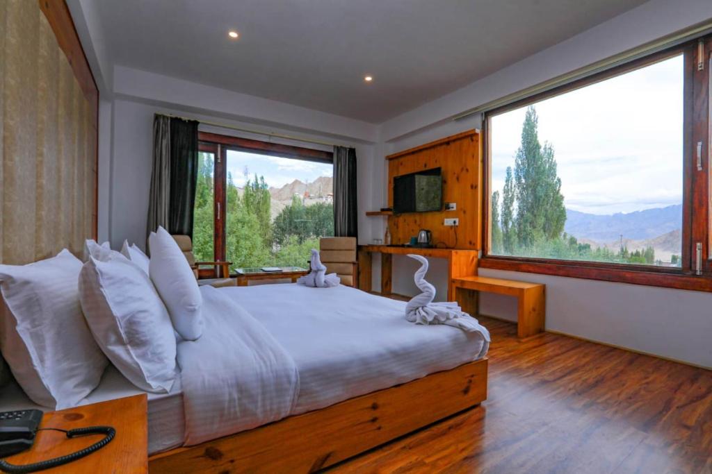 a bedroom with a large bed with a large window at Sky Desert in Leh