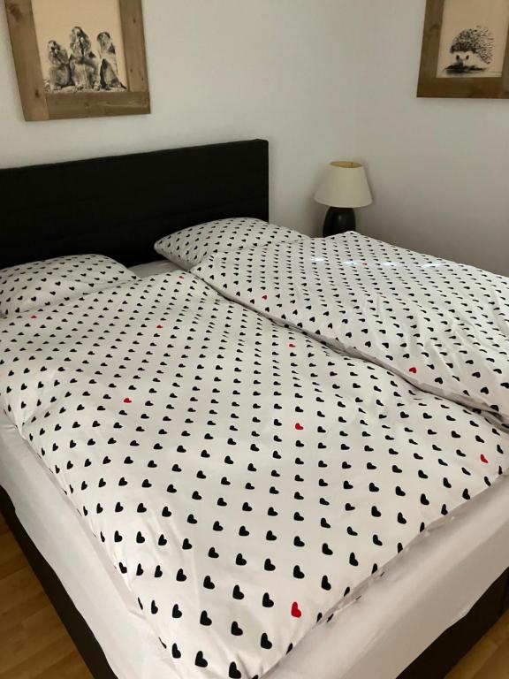 ein Bett mit einer schwarzen und weißen Bettdecke darauf in der Unterkunft Vazerol in Lenzerheide