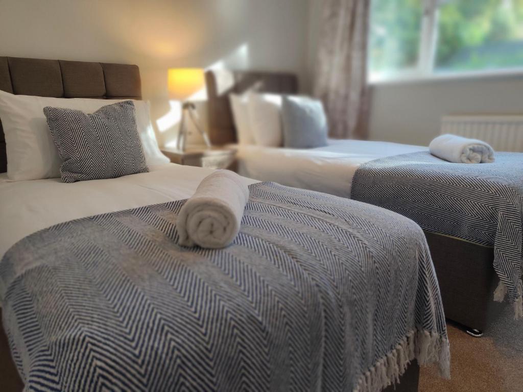 a hotel room with two beds with towels on them at Piping Green 5 bedroom House in Winchester