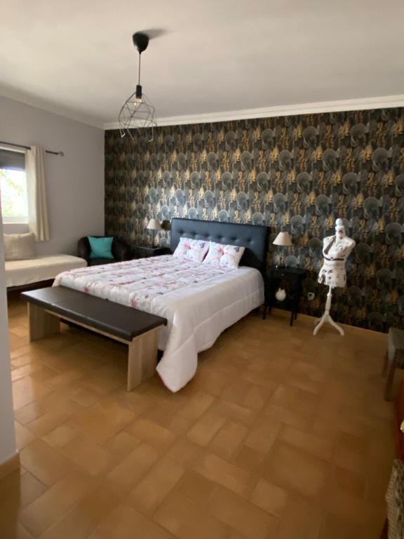 een slaapkamer met een groot bed en een muur bij Casa da azinheira in Loulé